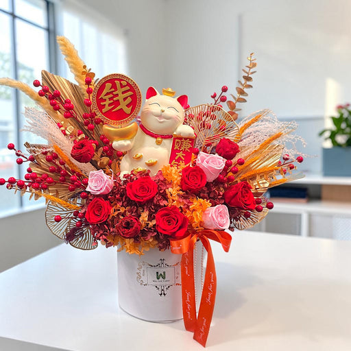 Golden Fortune Cat preserved rose arrangement with ceramic lucky cat and gold ingot, close-up on marble counter