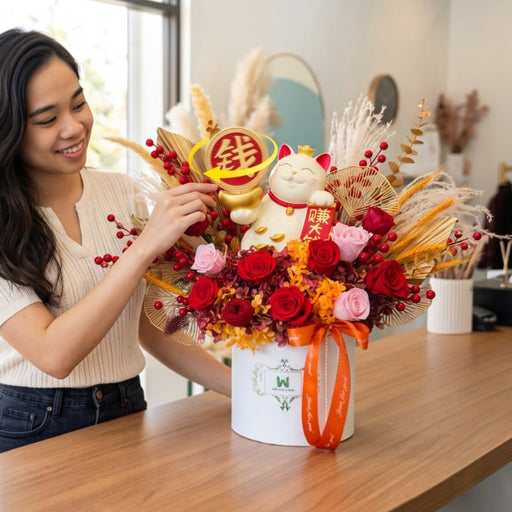 Florist arranging Golden Fortune Cat preserved flower box with spinning 赚大钱 token