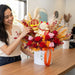 Florist arranging Golden Fortune Cat preserved flower box with spinning 赚大钱 token