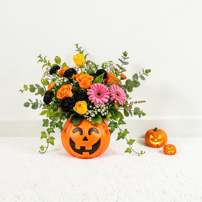 Halloween pumpkin flower arrangement with yellow tulips, black carnations and trailing ivy, same day flower delivery in Singapore