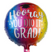 A round foil balloon with a colorful rainbow gradient background and the text 'Hooray YOU DID IT GRAD!' in white script and block lettering, with a small graduation cap graphic near the top. 