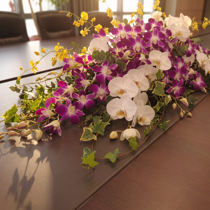 Fresh orchid centerpiece with white phalaenopsis, purple dendrobium and golden ramsey.