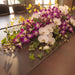 Fresh orchid centerpiece with white phalaenopsis, purple dendrobium and golden ramsey.