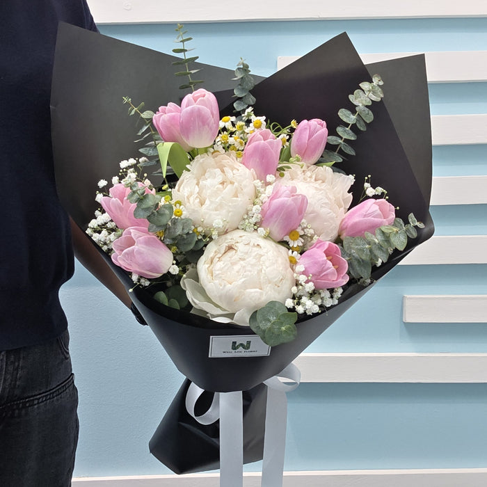 Hand-crafted fresh flower bouquet with pink tulips, white peonies, and delicate greenery for special occasions