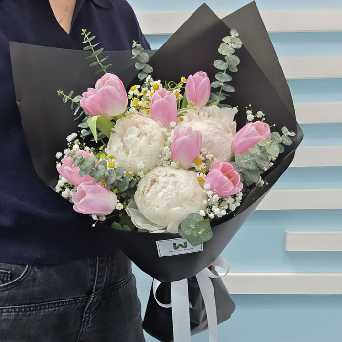 Peony Tulip Reverie bouquet featuring soft pink tulips, white peonies, daisies, baby's breath, and eucalyptus greenery
