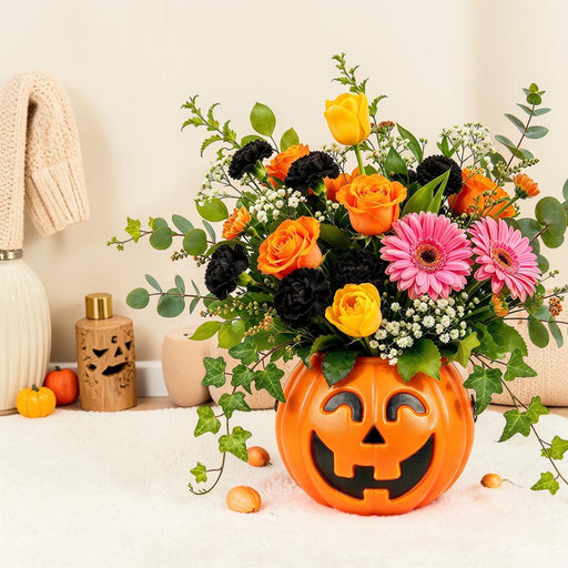 Smiling jack-o’-lantern pumpkin bouquet with fresh flowers styled as Halloween home decor