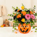 Smiling jack-o’-lantern pumpkin bouquet with fresh flowers styled as Halloween home decor