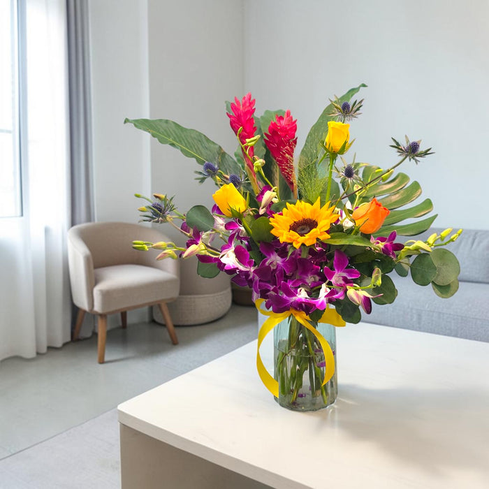 Fresh flower vase arrangement Tropicana Sunrise displayed on coffee table for birthday gifting