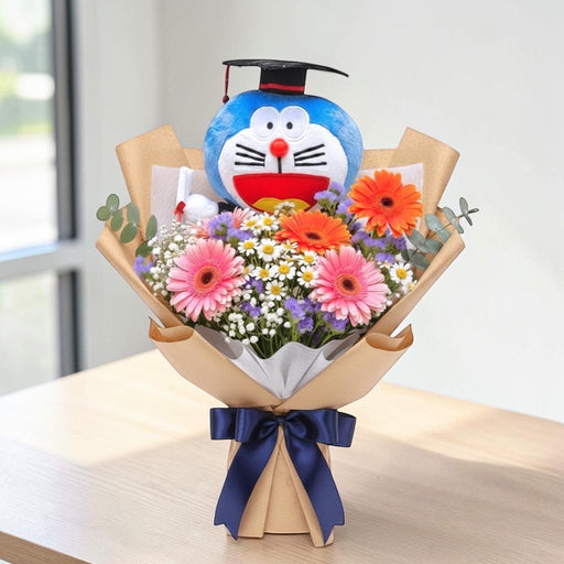 "Turn the Tassel" graduation flower bouquet featuring fresh gerberas, daisies, baby's breath, and a Doraemon graduation bear plush, available for delivery in Singapore.