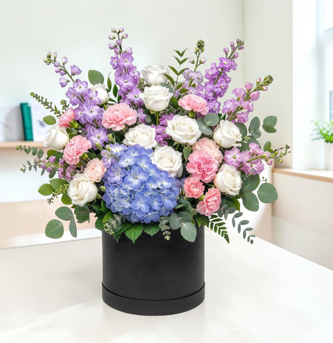 Pastel Daydream fresh flower arrangement in a black hatbox with eucalyptus, for Singapore delivery