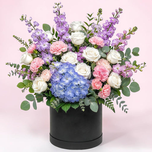 Pastel Daydream flower hatbox with white roses, pink carnations, lilac stock and blue hydrangea