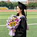 Graduate holding sunflower and rose graduation bouquet with teddy bear, Singapore