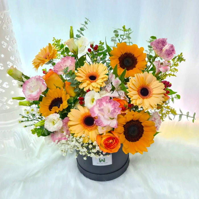Captivating flower box of cheerful fresh sunflower, gerbera, rose, Eustoma, baby breath, filler and foliage.