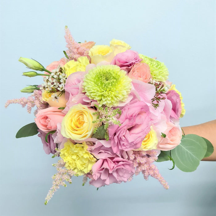 Dazzling hand bouquet of enthralling garden roses, eustoma, hydrangea and filler flower