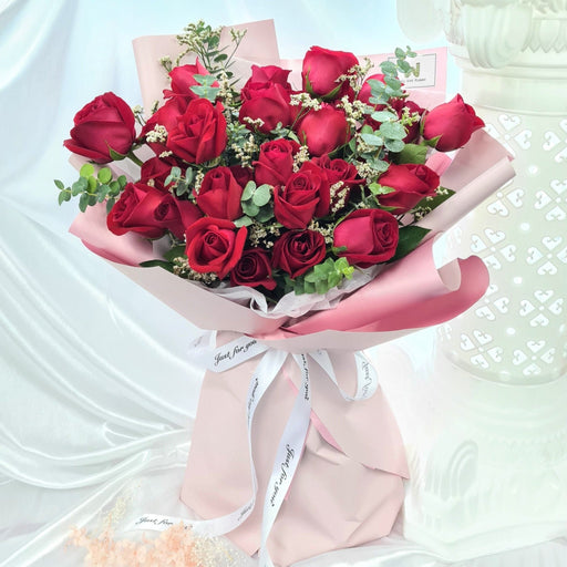 Exquisite hand bouquet of red color roses, caspia and foliage.