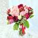 Exquisite hand bouquet of enticing pink / red roses, wax flower, eustoma and foliage