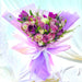 Mesmerising hand bouquet of elegant fresh purple roses, eustomas, tulip, pom pom, wax flower and foliage.