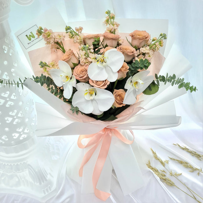 Charming hand bouquet of ravishing cappuccino roses, lovely phalaenopsis orchid , mathiola and foliage