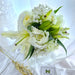 Charming hand bouquet of 10 enticing white roses and 3 beautiful white lilies.