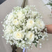Exquisite hand bouquet of enticing roses and baby's breath.