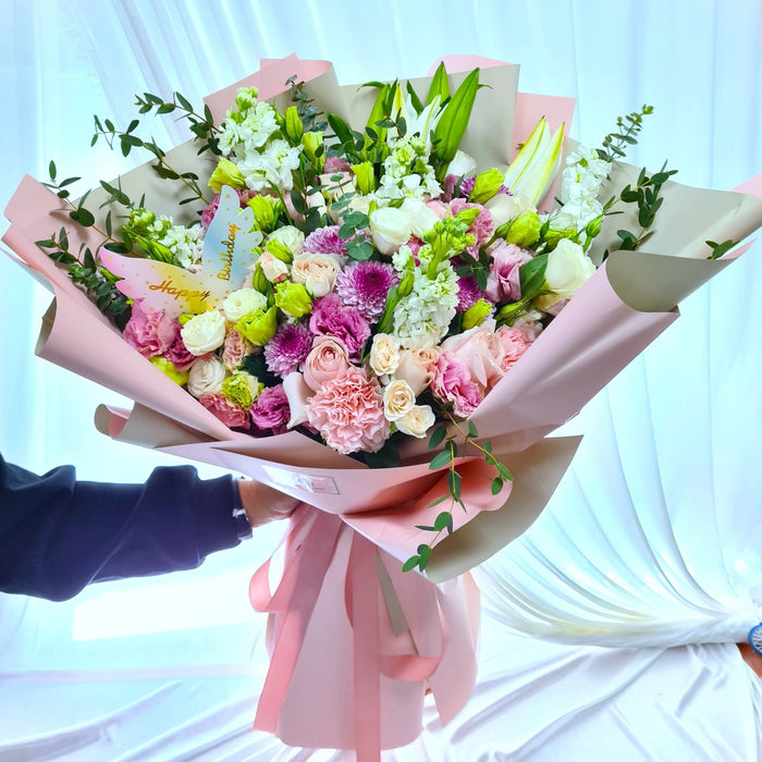 Captivating bouquet of stunning eustoma, pom pom, lily, and roses.