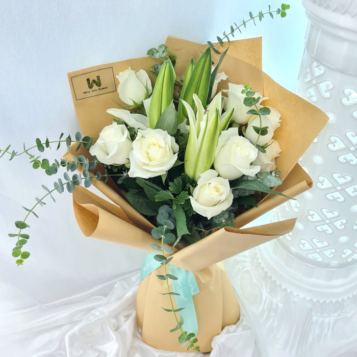 Alluring hand bouquet of 10 lovely roses, lily, and foliage.