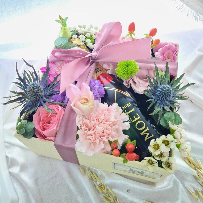Captivating flower box of glamorous roses, eustomas, carnation, pom pom, foliage and a bottle of Mini MOET Champagne 200ml.