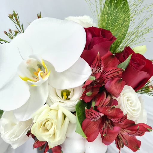 Enticing flower box of elegant fresh orchid, eustomas, cotton, alstroemeria, filler flowers and foliage.