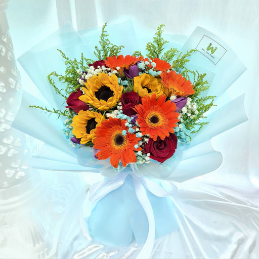 Bouquet includes sunflower, roses, gerbera, tulips, baby's breath and foliage.