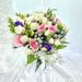 Graceful hand bouquet of pink roses, purple eustoma, filler and foliage