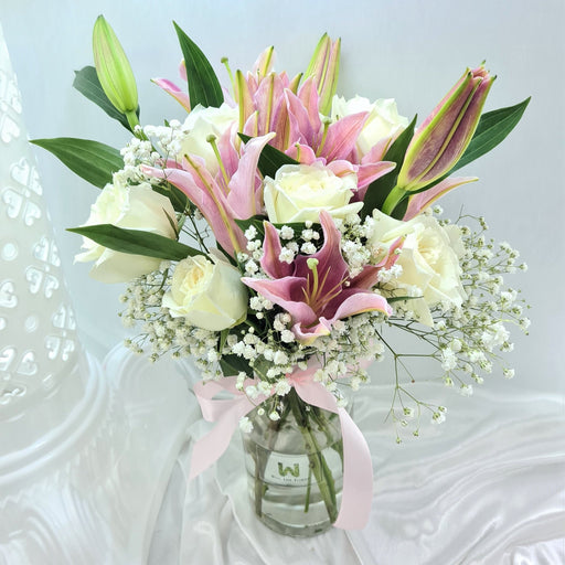 Gorgeous floral arrangement placed in an elegant vase.  Comes with pink lilies and white roses and baby's breath