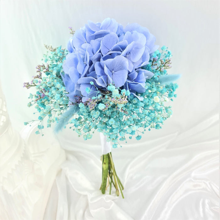 Exquisite hand bouquet of enticing blue hydrangea and baby's breath.