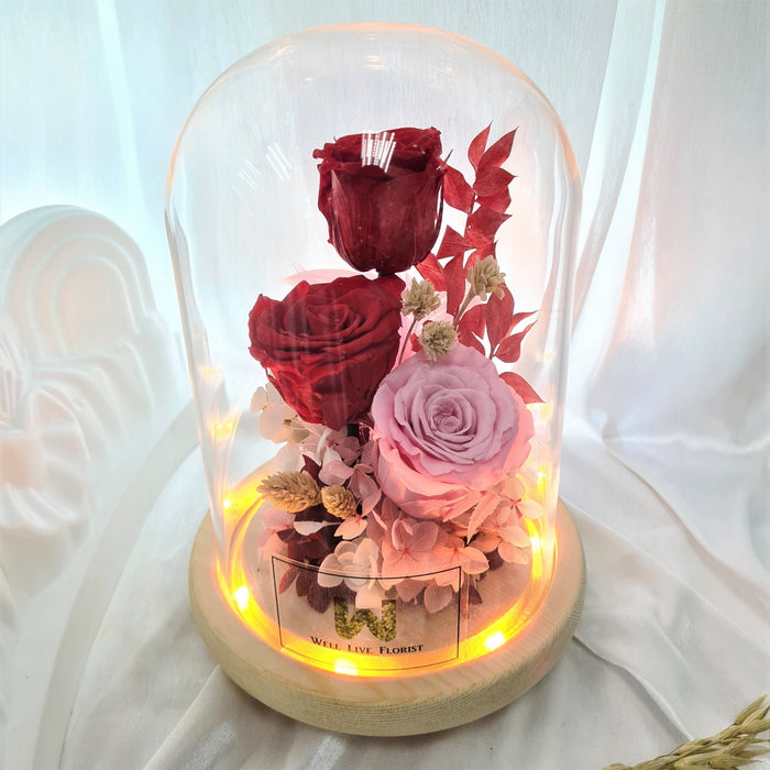Captivating combination of preserved blue roses, hydrangeas, and dried foliage in glass dome to celebrate the day.