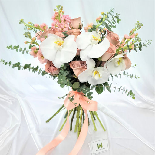 Charming hand bouquet of ravishing cappuccino roses, lovely phalaenopsis orchid , mathiola and foliage.