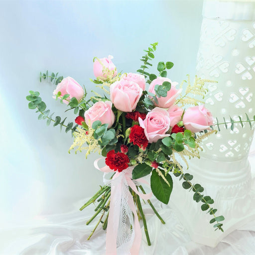 Captivating hand bouquet of irresistible roses, carnation, and foliage.